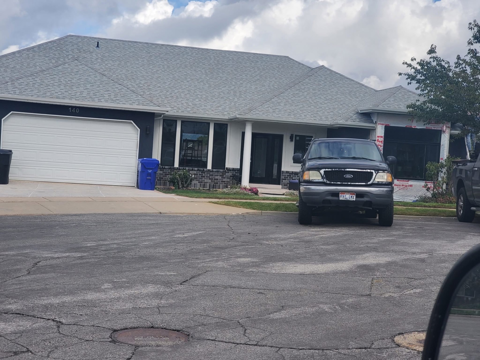 New gray shingle hip roof on a single-story home
