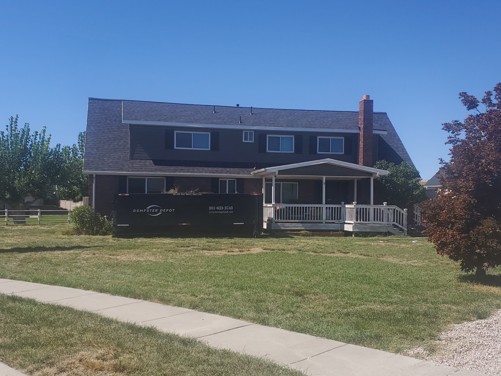 Two-story home with a new dark shingle roof and covered porch