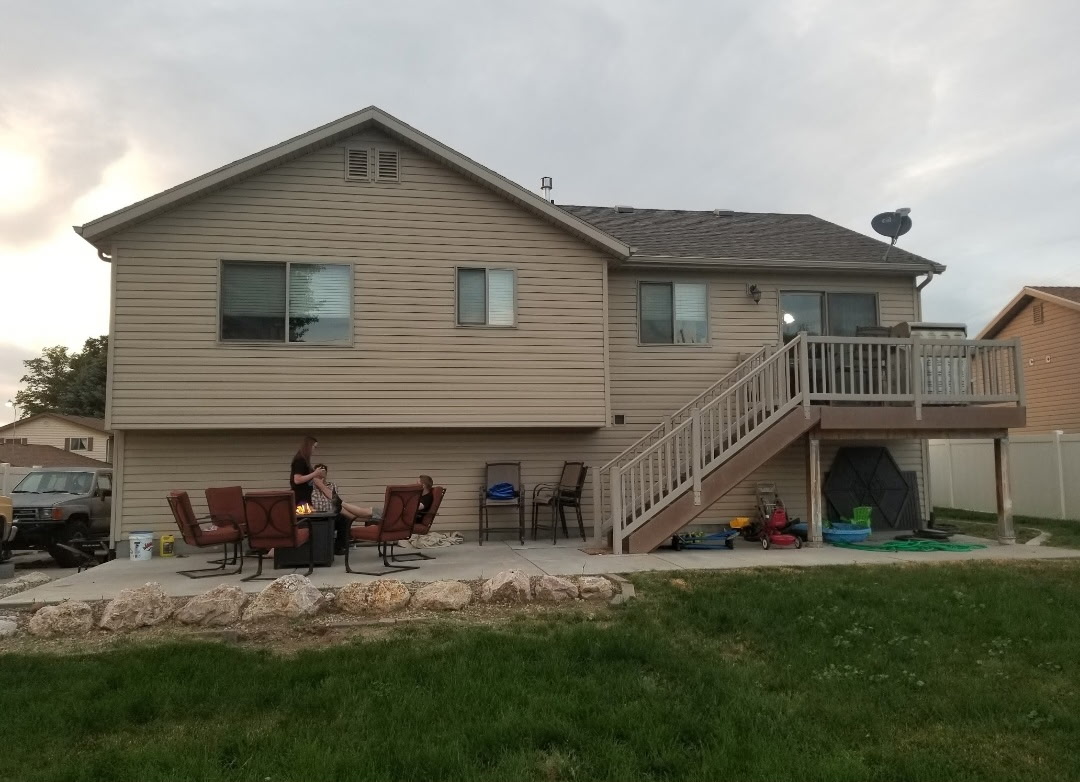 Two-story home with siding and a backyard deck with stairs
