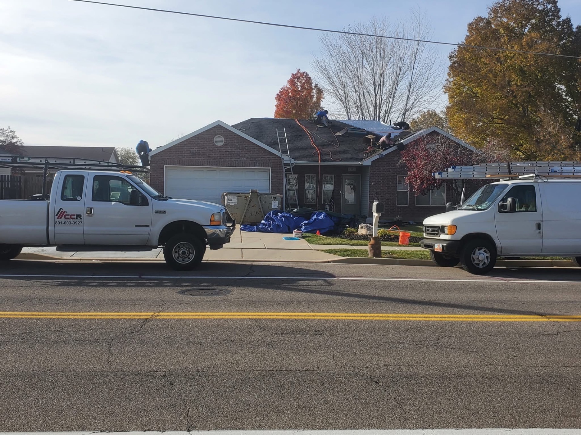 CCR crew replacing a shingle roof with company truck out front