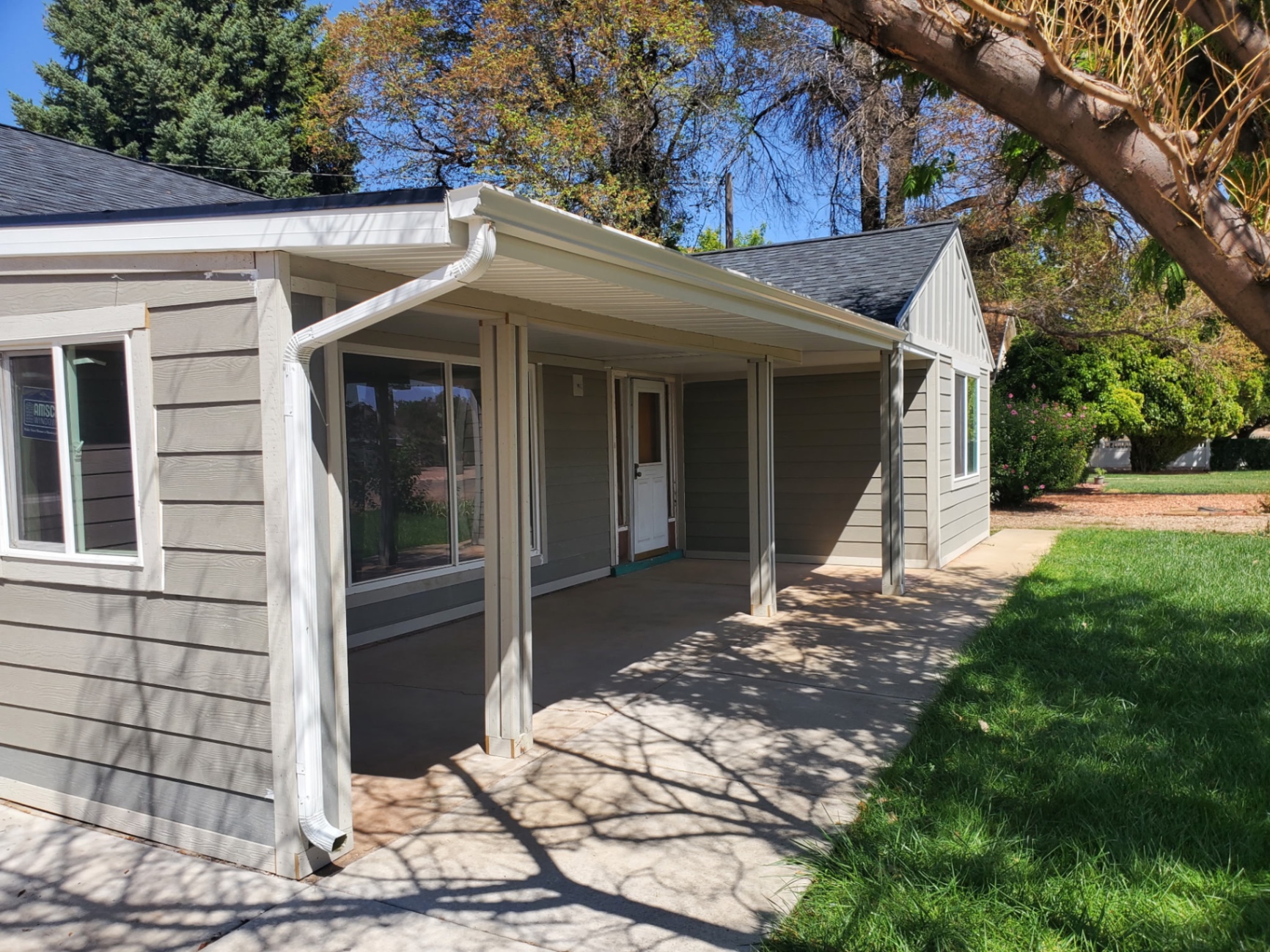 Covered patio with gutters along a finished home exterior