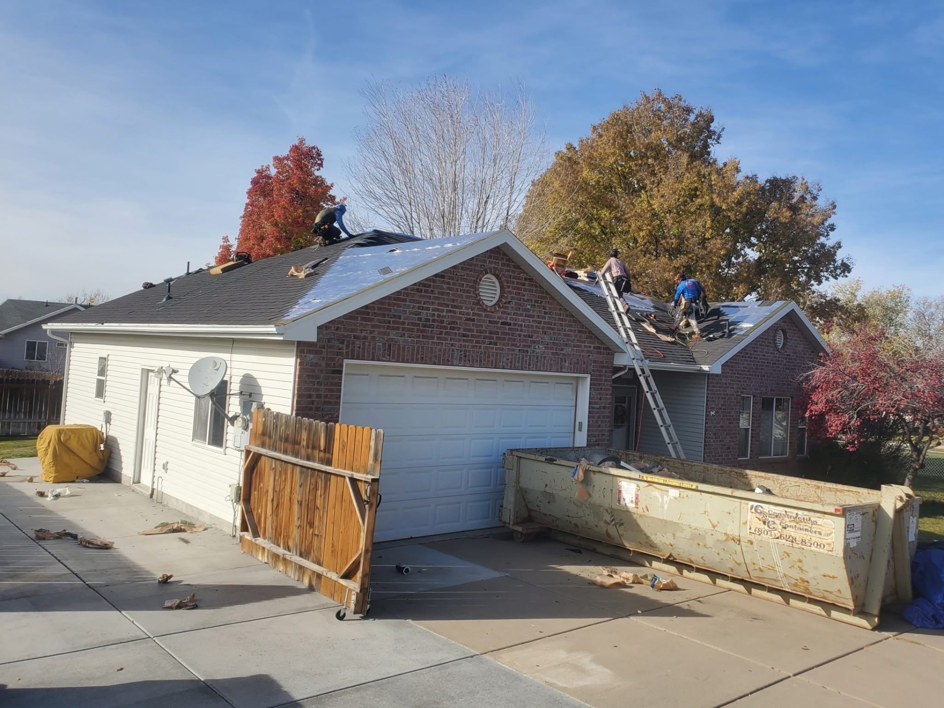 Crew installing underlayment on a brick home